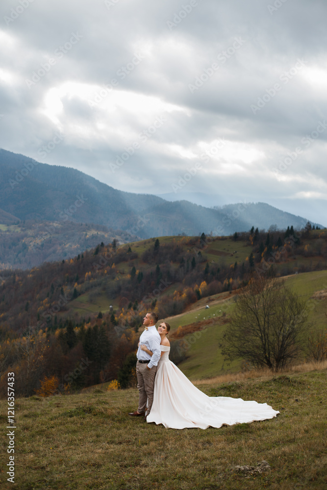 couple standing against the backdrop of a picturesque mountain landscape. A man and a woman look at each other. couple standing against the backdrop of a picturesque mountain landscape. A man and a woman look at each other.