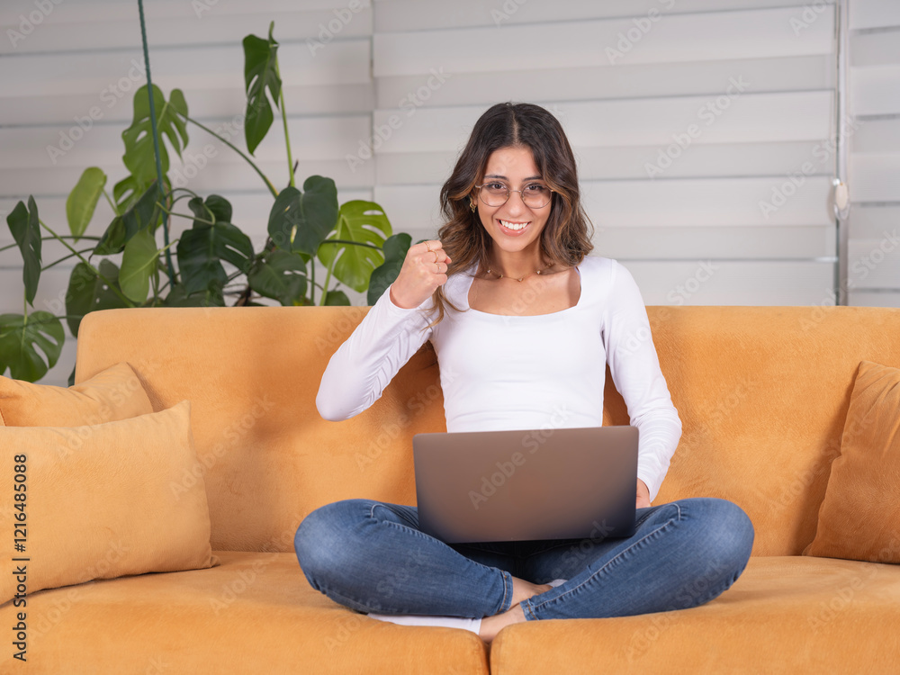 Winner woman, full body view young caucasian winner woman sit on sofa holding laptop clenched fist screaming smiling while reading news online. Celebrating. Got great offer from work, success concept. Winner woman, full body view young caucasian winner woman sit on sofa holding laptop clenched fist screaming smiling while reading news online. Celebrating. Got great offer from work, success concept.