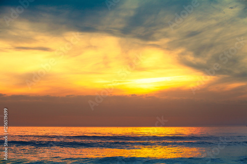Obraz na płótnie Seascape in the early morning. Beautiful golden dramatic sunrise over the sea w salonie