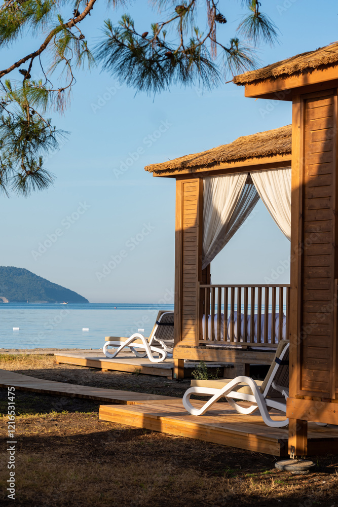 Private beach cabanas on a serene sandy shoreline at sunset Private beach cabanas on a serene sandy shoreline at sunset