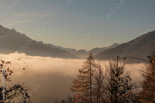 Vista panoramica di un ambiente naturale di montagna nel nord Italia con cielo sereno e nuvole basse in inverno