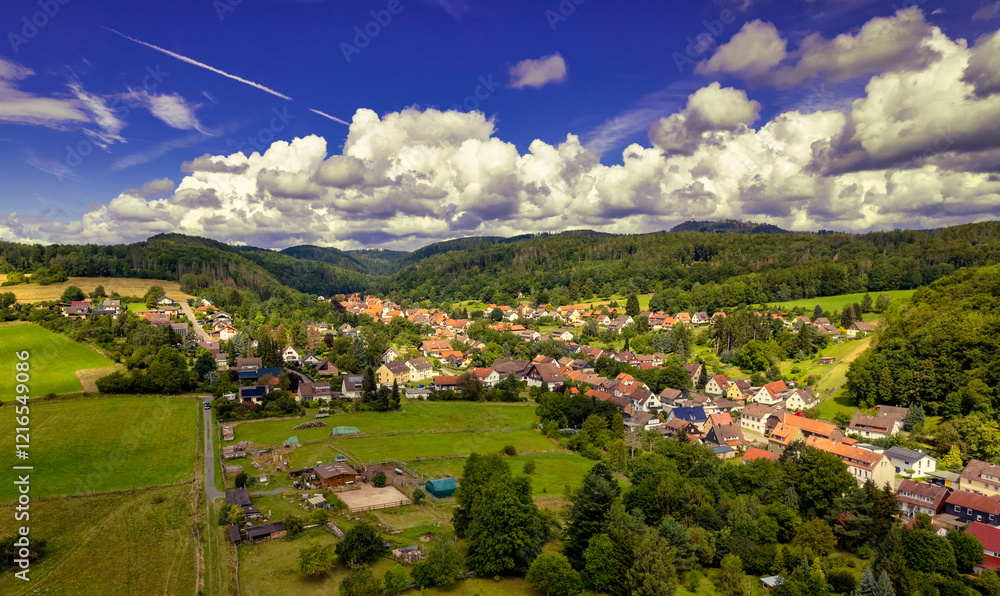 Vibrant German Village Nestled in a Valley Surrounded by Lush Greenery and Picturesque Mountains on a Bright Sunny Day