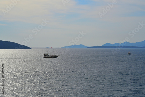 View from Turkish mainland near port town of Bodrum, Mugla province on the sea with yachts, speed and tourist sail boats and island Kara Ada.  photo