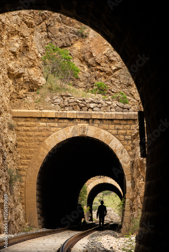 Railway tunnel and walking people silhouette photo