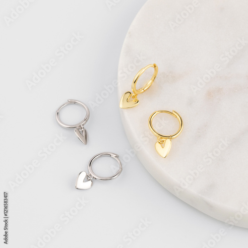 A pair of gold and silver earrings in the shape of hearts. Jewelry catalog.