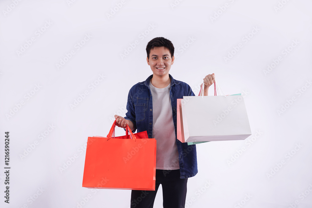 Portrait of young Asian man holding shopping bag posing on white background Portrait of young Asian man holding shopping bag posing on white background