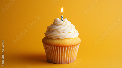 Delicious birthday cupcake topped with a lit candle on a vibrant yellow background, perfect for a party celebration or festive birthday theme photo