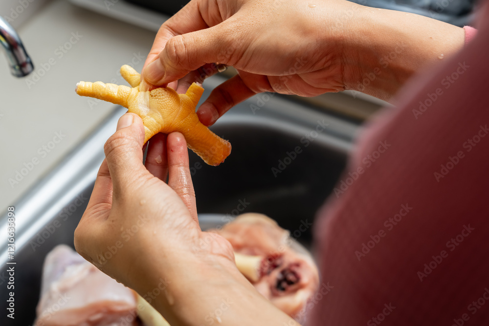 Obraz premium Rinsing chicken feet under running water, home cook food preparation