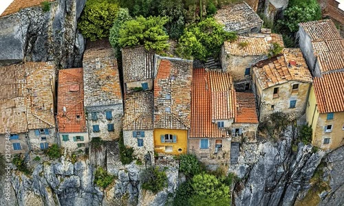 Aerial view of colorful cliffside houses surrounded by greenery