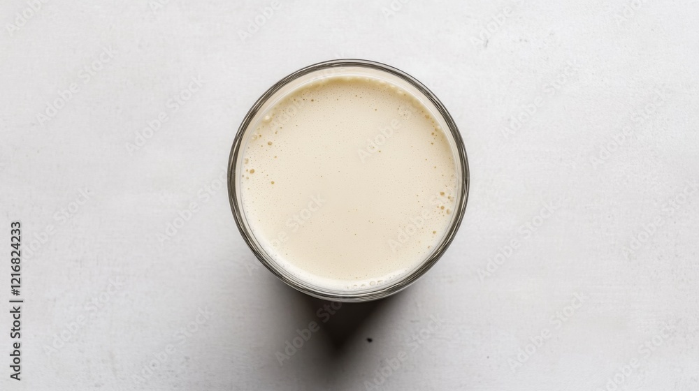 A close-up view of a glass filled with creamy liquid on a light surface, evoking freshness A close-up view of a glass filled with creamy liquid on a light surface, evoking freshness