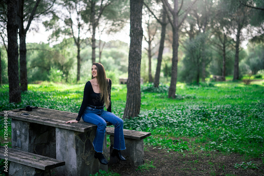 Chica joven delgada vloggeando con cámara por zona verde con arboles