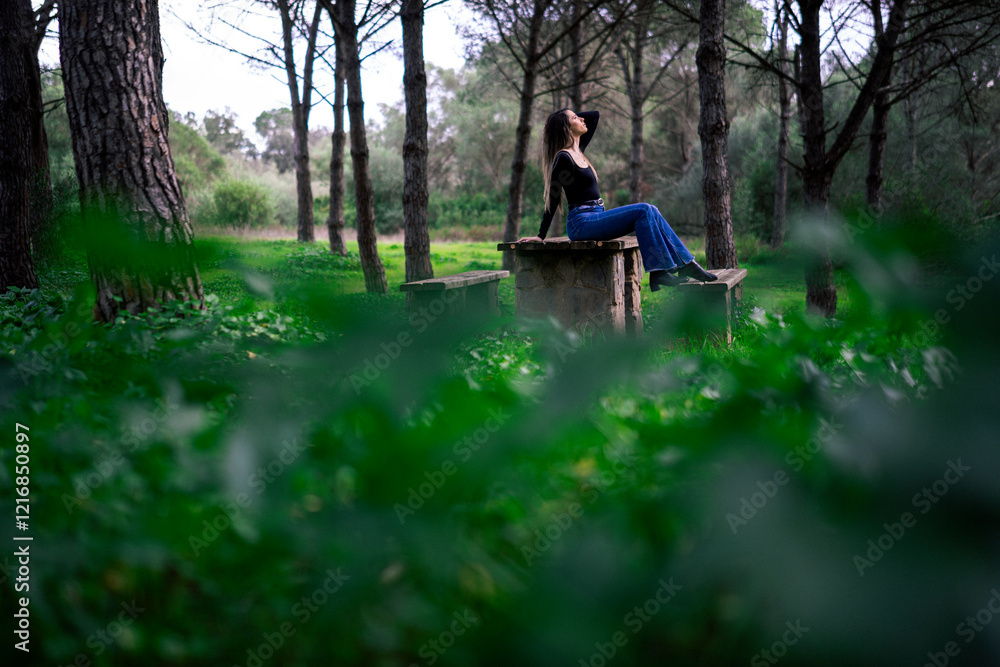 Chica joven delgada vloggeando con cámara por zona verde con arboles