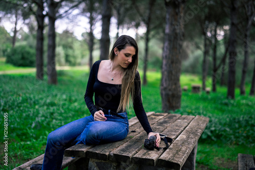 Obraz na płótnie Chica joven delgada vloggeando con cámara por zona verde con arboles w salonie