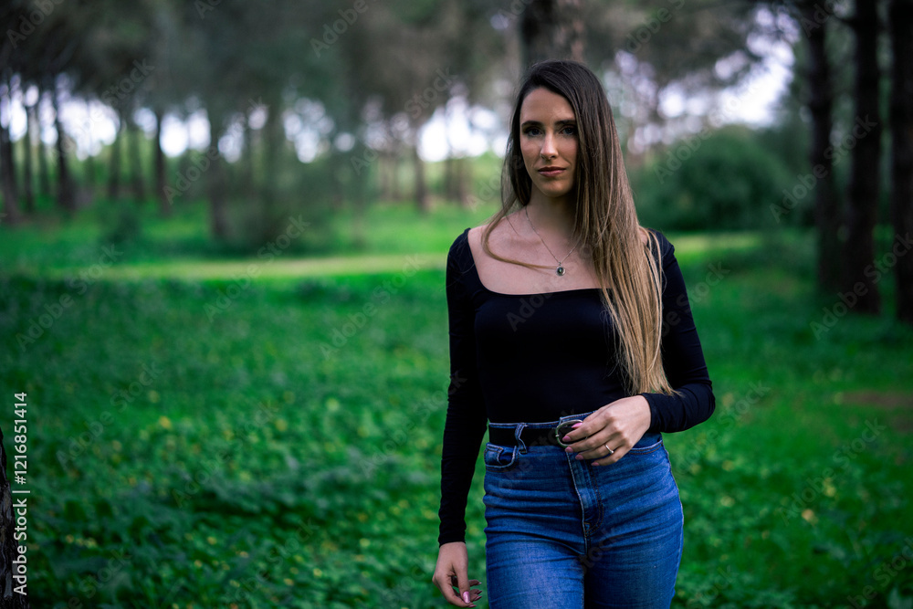 Chica joven delgada vloggeando con cámara por zona verde con arboles