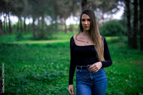 Obraz na płótnie Chica joven delgada vloggeando con cámara por zona verde con arboles w salonie