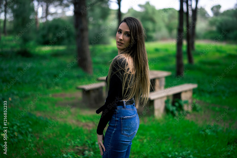 Chica joven delgada vloggeando con cámara por zona verde con arboles