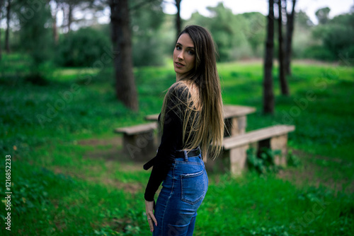 Obraz na płótnie Chica joven delgada vloggeando con cámara por zona verde con arboles w salonie