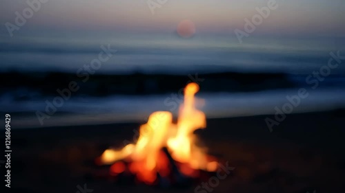 Serene bonfire on seashore during sunset with gentle ocean waves