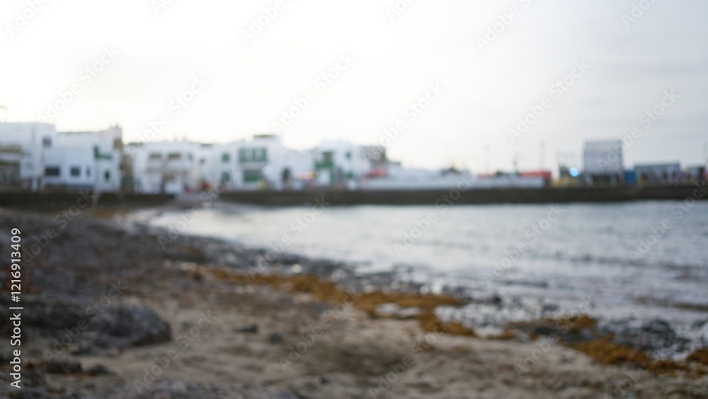 Blurry seaside view in lanzarote with an out-of-focus beachfront and defocused buildings in the background, capturing the essence of a coastal town in the canary islands of spain. Blurry seaside view in lanzarote with an out-of-focus beachfront and defocused buildings in the background, capturing the essence of a coastal town in the canary islands of spain.