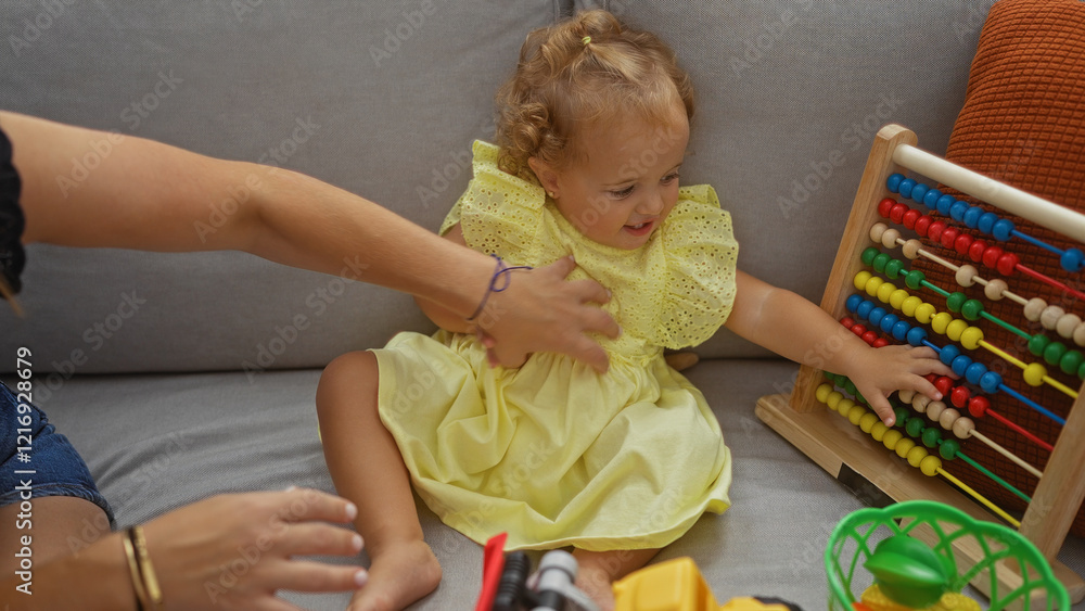 Toddler girl playing with colorful abacus in living room while being supervised at home showcasing cheerful and interactive childhood moments Toddler girl playing with colorful abacus in living room while being supervised at home showcasing cheerful and interactive childhood moments