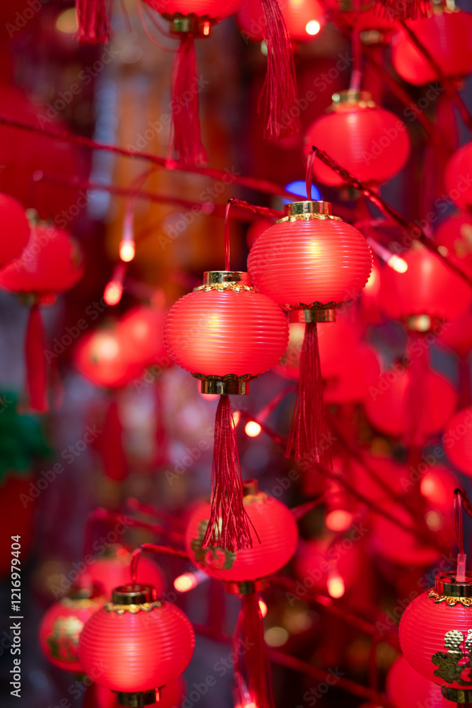 Red lanterns glow warmly, celebrating Lunar New Year. Festive lights illuminate the night, creating a vibrant atmosphere.