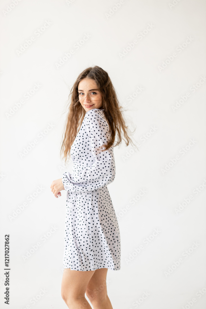 beautiful woman model posing in white polka dot dress in studio beautiful woman model posing in white polka dot dress in studio