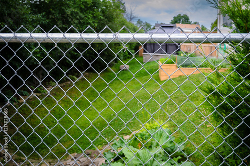 Suburban backyard decks and garden behind a chain-link fence photo