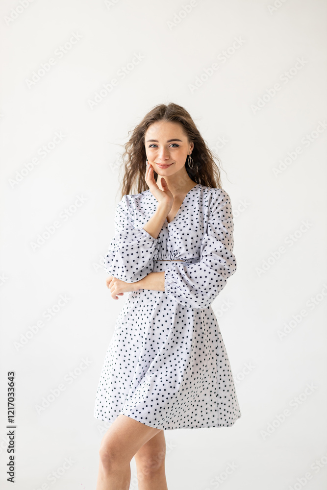 beautiful woman model posing in white polka dot dress in studio beautiful woman model posing in white polka dot dress in studio