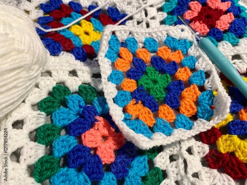 Granny square crocheted blanket with different colors motives, retro vintage craft handmade handiwork crocheting, beautiful plied photo cozy winter or autumn background wool thing yarn lovely warm photo