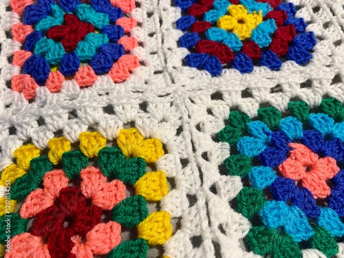 Granny square crocheted blanket with different colors motives, retro vintage craft handmade handiwork crocheting, beautiful plied photo cozy winter or autumn background wool thing yarn lovely warm photo