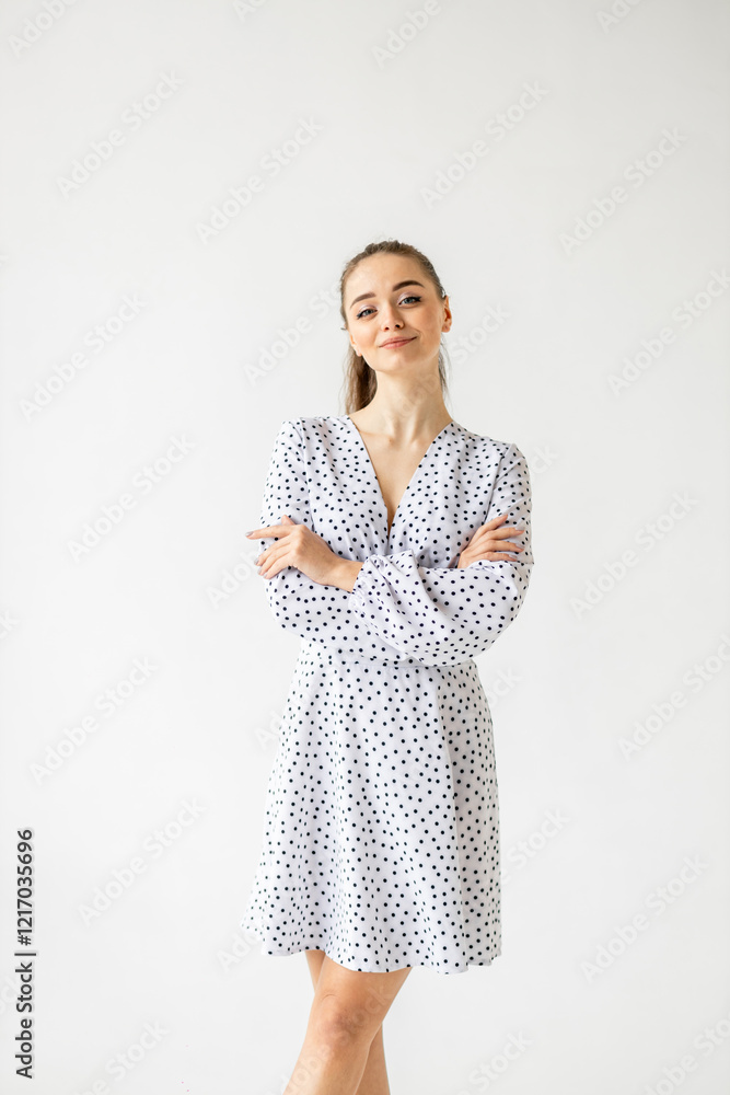 beautiful woman model posing in white polka dot dress in studio beautiful woman model posing in white polka dot dress in studio