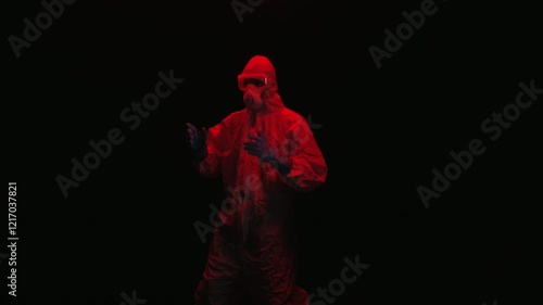 Scientist in PPE doing multiple poses in a dark room
