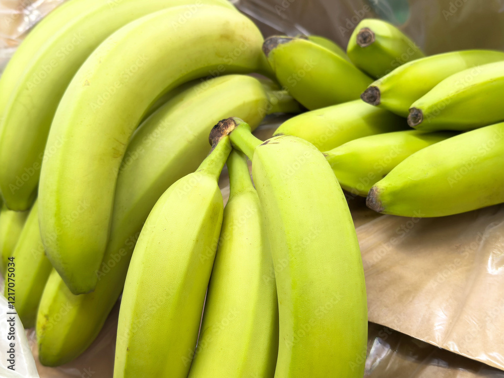 Fresh green bananas on display at a market stall Fresh green bananas on display at a market stall