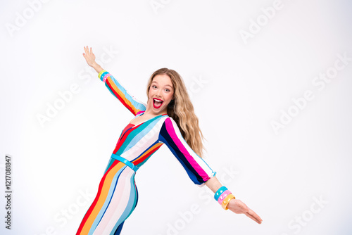 Fototapete Young woman in colorful striped overall poses joyfully against a white backgroun