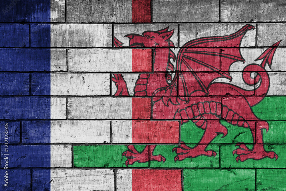 Obraz premium colourful painted big flag of france and flag of wales on a massive old brick wall background. concept