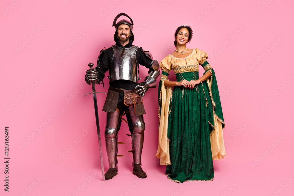 Man in knight armor and woman in noble costume posing on pink background Man in knight armor and woman in noble costume posing on pink background