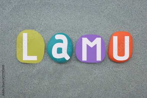 Lamu, small town on Lamu Island, which in turn is a part of the Lamu Archipelago in Kenya, souvenir composed with multi colored hand painted stone letters over green sand