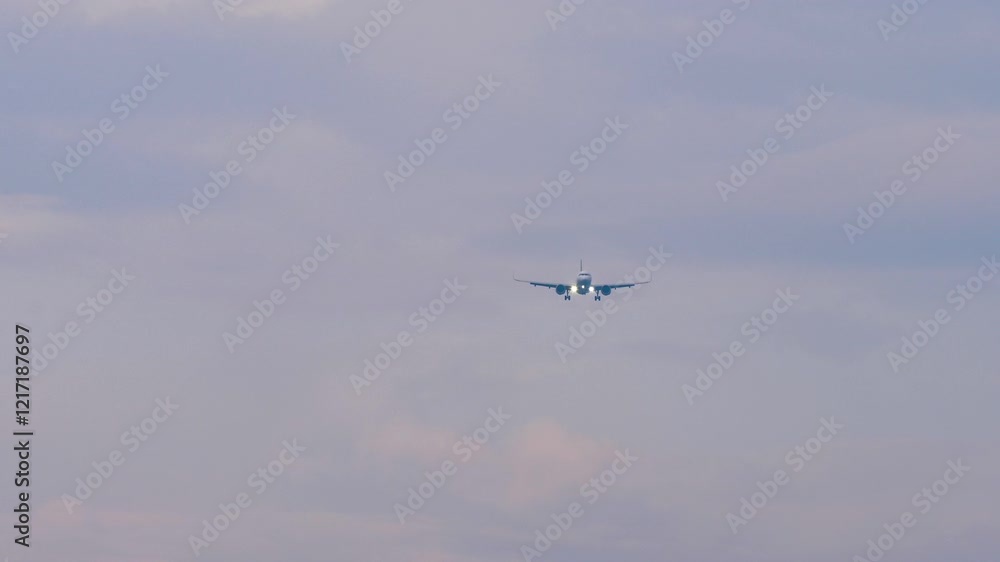 Commercial airplane with unrecognizable livery approaching landing, long shot, front view Commercial airplane with unrecognizable livery approaching landing, long shot, front view