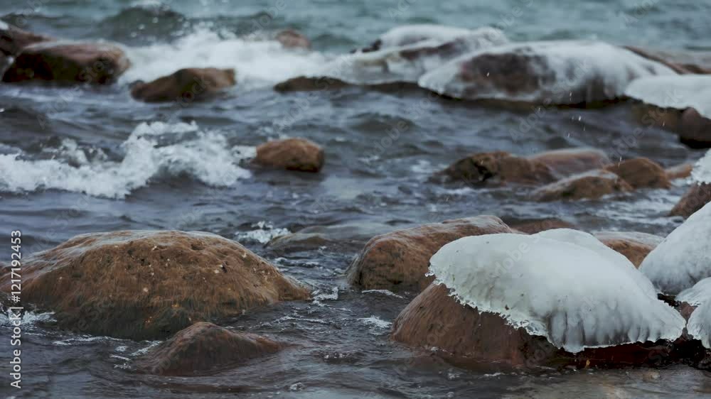 A stunning winter scene: a lighthouse stands amidst icy rocks and snow. Waves crash against the shore, blending water and foam, while the wind adds drama. Frozen beauty captures the essence of winte A stunning winter scene: a lighthouse stands amidst icy rocks and snow. Waves crash against the shore, blending water and foam, while the wind adds drama. Frozen beauty captures the essence of winte