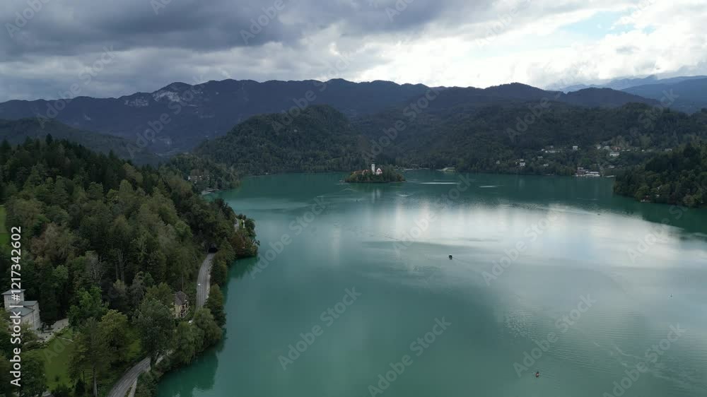 aerial drone view of lake bled, slovenia with island church in the distance on overcast cloudy day (scenic famous travel tourism destination in julian alps europe) european fairytale location aerial drone view of lake bled, slovenia with island church in the distance on overcast cloudy day (scenic famous travel tourism destination in julian alps europe) european fairytale location