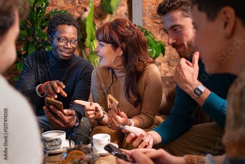 Multiracial friends socializing and using smartphones at a cozy café
