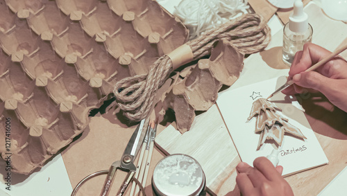 Painting the details of a Christmas tree made of recycled egg carton that shows a creative DIY sustainable holiday season craft project