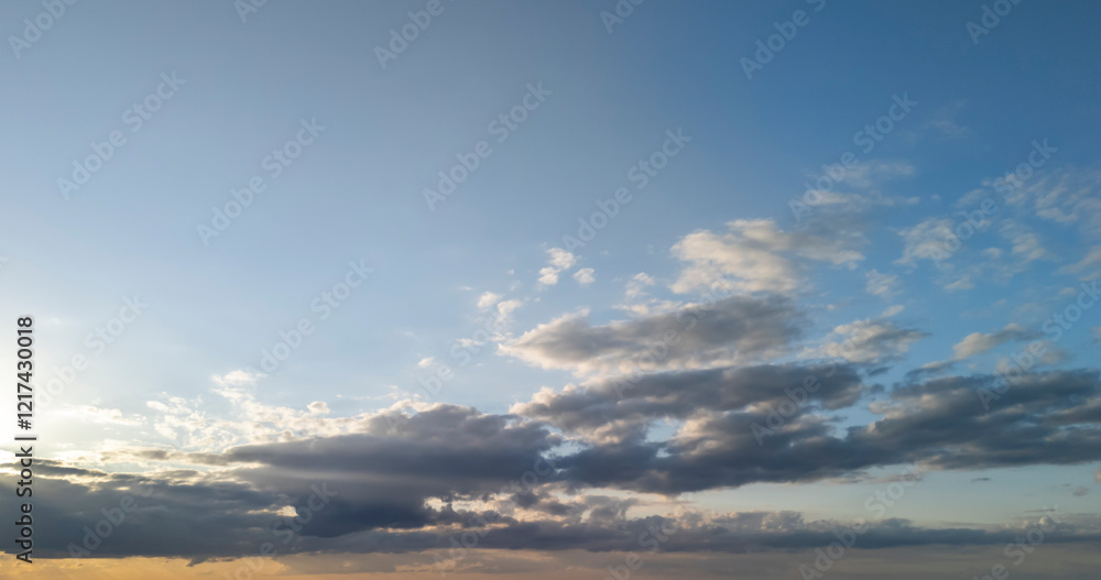 Obraz premium A serene sky at sunset, displaying soft clouds and a gradient of warm colors. Perfect for nature-themed projects and calm atmospheres.