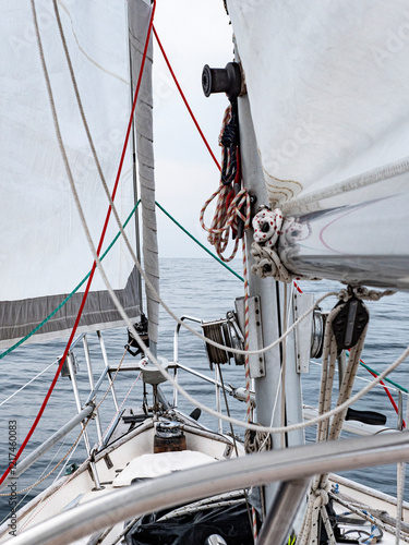 Photography Look over the bow of a sailboat with mainsail and rolling furler genoa set