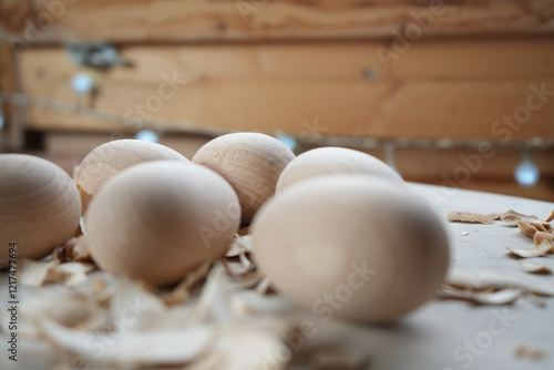 Close-up of wooden eggs with wood shavings on a light surface, highlighting natural textures, craftsmanship, and rustic aesthetics, perfect for themes of handmade crafts, woodworking, or minimal desig photo