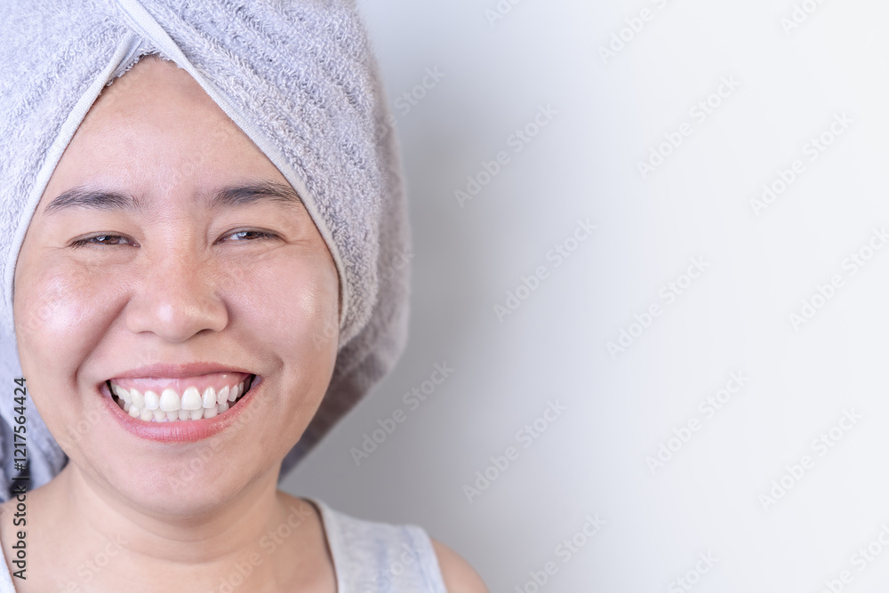 Close-up of a happy Asian woman with a towel on her head, smiling cheerfully. healthy skin After receiving facial care and skin concepts. Cosmetics, skincare, and spa treatments. Close-up of a happy Asian woman with a towel on her head, smiling cheerfully. healthy skin After receiving facial care and skin concepts. Cosmetics, skincare, and spa treatments.