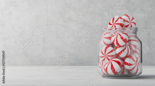 Colorful peppermint candies in a glass jar on a light textured background for festive themes and holiday decor photo