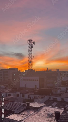  Sunset view of a city with a golden sky, a signal antenna, and the urban landscape
