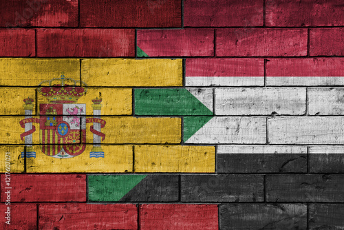 colourful painted big flag of spain and flag of sudan on a massive old brick wall background. concept photo