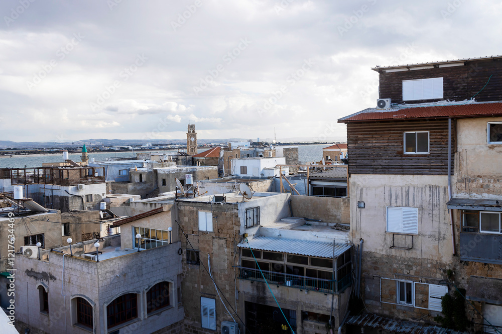 Acre, Israel, January 25, 2025, View from the roof of the guesthouse to the old city with mosques and churches, the sea on the horizon, and the sky with clouds. Acre, Israel, January 25, 2025, View from the roof of the guesthouse to the old city with mosques and churches, the sea on the horizon, and the sky with clouds.
